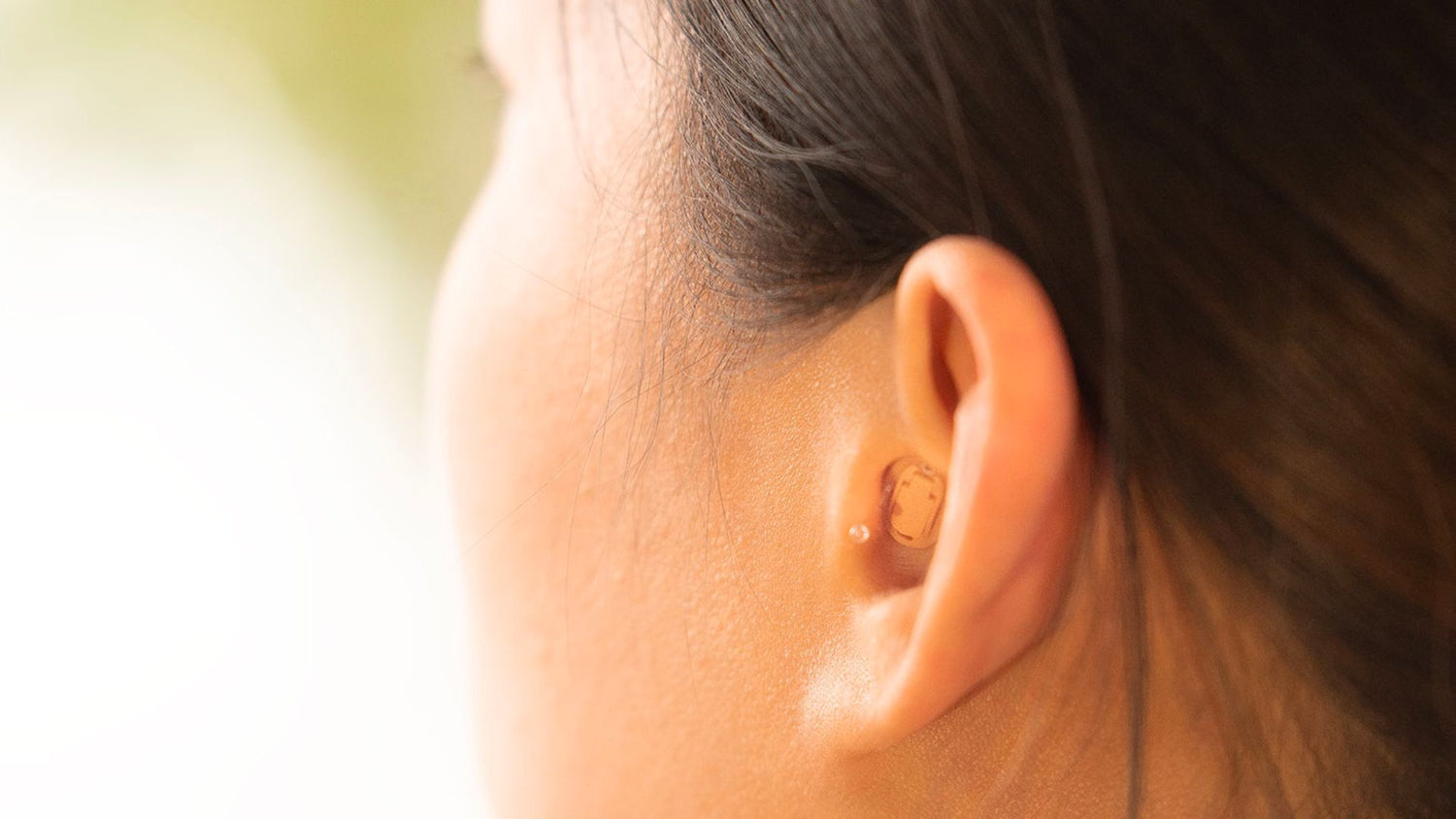 woman wearing cic custom hearing aids